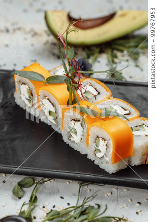 Rainbow Sushi Roll with salmon, eel, tuna, avocado, royal prawn, cream cheese Philadelphia, caviar tobica, chuka. Sushi menu. Japanese food.  99767953