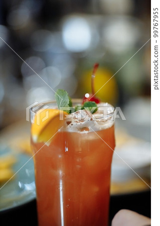 Refreshing grapefruit cocktail with ice and rosemary on a grey background. Refreshing grapefruit cocktail with ice and rosemary on a grey background. 99767955