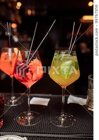 Refreshing grapefruit cocktail with ice and rosemary on a grey background. Refreshing grapefruit cocktail with ice and rosemary on a grey background. 99767956