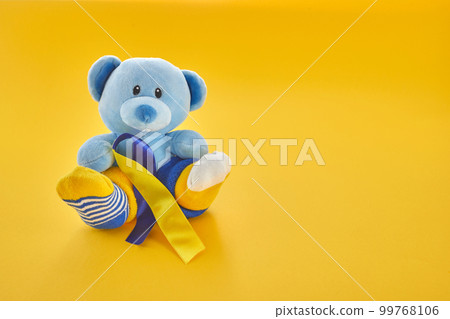 World Down Syndrome day background.Teddy bear with different socks on yellow background. World Down Syndrome day background.Teddy bear with different socks on yellow background. 99768106
