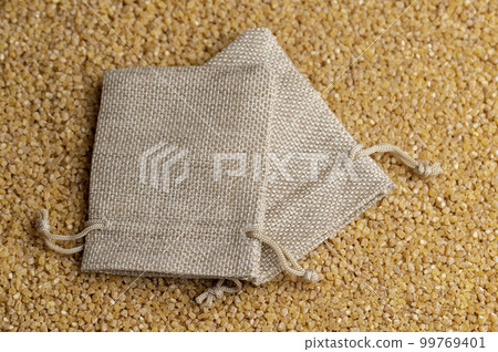 Not cooked wheat porridge in a linen bag 99769401