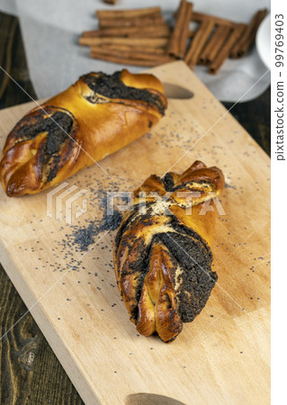 Fresh bun with poppy seed filling on the table Fresh bun with poppy seed filling on the table 99769403