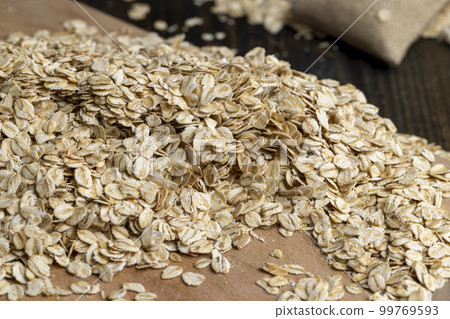 Poured a large amount of oat flakes close-up 99769593