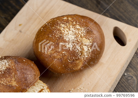 Wheat bun with large pieces of processed cheese inside 99769596