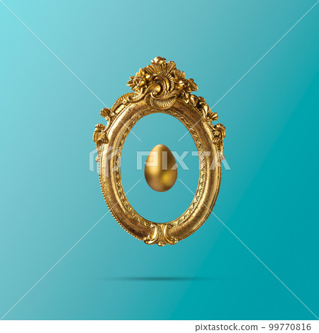 Golden egg in old golden vintage frame. Minimal elegant Easter composition Golden egg in old golden vintage frame. Minimal elegant Easter composition 99770816