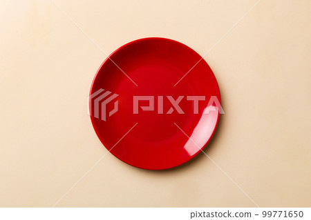 Top view of isolated of colored background empty round red plate for food. Empty dish with space for your design Top view of isolated of colored background empty round red plate for food. Empty dish with space for your design 99771650