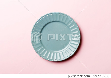 Top view of isolated of colored background empty round blue plate for food. Empty dish with space for your design 99771652