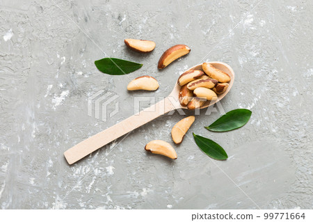 Fresh healthy brazil nuts in spoon on colored table background. Top view Healthy eating concept. Super foods 99771664