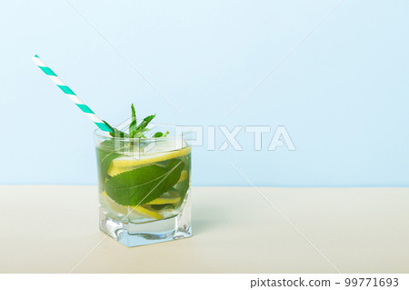 Mojito summer refreshing cocktail with ice and mint. mojito cocktail with lime, lemon and mint in a tall glass with a stick Mojito summer refreshing cocktail with ice and mint. mojito cocktail with lime, lemon and mint in a tall glass with a stick 99771693