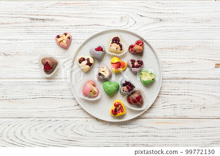 Plate with different chocolate on colored background. Assortment of fine chocolates top view vith copy space Health and obesity concept 99772130