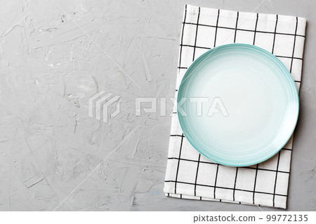 Top view on colored background empty round blue plate on tablecloth for food. Empty dish on napkin with space for your design 99772135