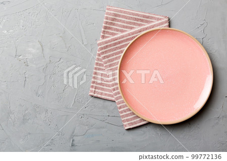 Top view on colored background empty round pink plate on tablecloth for food. Empty dish on napkin with space for your design 99772136