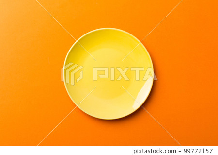 Top view of isolated of colored background empty round yellow plate for food. Empty dish with space for your design Top view of isolated of colored background empty round yellow plate for food. Empty dish with space for your design 99772157
