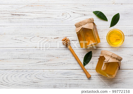Honey jar with wooden honey dipper on white background top view with copy space. Delicious honey bottle 99772158