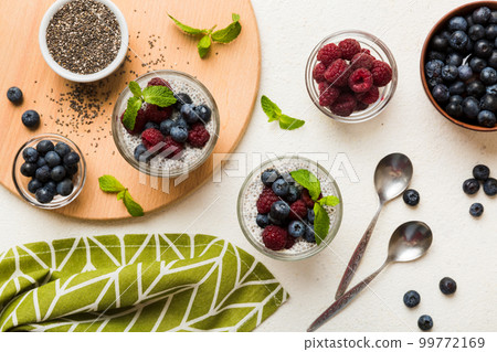 Healthy breakfast or morning with chia seeds vanilla pudding raspberry and blueberry berries on table background, vegetarian food, diet and health concept. Chia pudding with raspberry and blueberry Healthy breakfast or morning with chia seeds vanilla pudding raspberry and blueberry berries on table background, vegetarian food, diet and health concept. Chia pudding with raspberry and blueberry 99772169