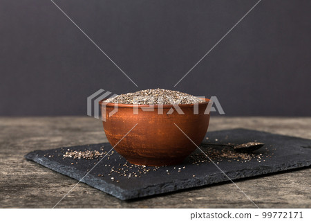 Chia seeds in bowl and spoon on colored background. Healthy Salvia hispanica in small bowl. Healthy superfood Chia seeds in bowl and spoon on colored background. Healthy Salvia hispanica in small bowl. Healthy superfood 99772171