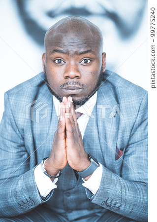 Creative Director is Ready to Present a New Idea to Increase the Company's Rating in the Global Marketing . Man from South Africa in Classic Suit with Folded Hands has a Good Idea. Close-up Portrait Creative Director is Ready to Present a New Idea to Increase the Company's Rating in the Global Marketing . Man from South Africa in Classic Suit with Folded Hands has a Good Idea. Close-up Portrait 99775240
