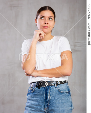 Thoughtful young woman standing in contemplative position 99775629