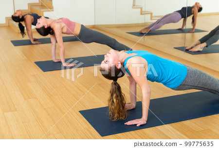 Girl doing Purvottanasana or Upward Plank pose during yoga workout 99775635