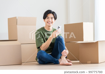 A young man looking at a smartphone while moving 99775780