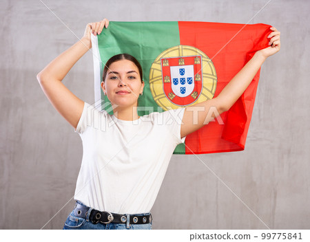Smiling young woman holding Portugal flag Smiling young woman holding Portugal flag 99775841