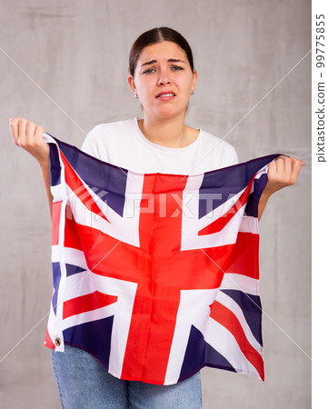 Irritated young woman with Britannic flag. Isolated on gray background 99775855