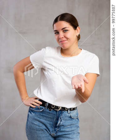 Smiling young woman in casual clothes gesturing 99775887