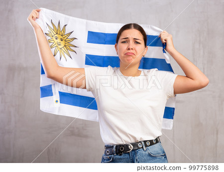 Sad girl with flag of Uruguay in her hands Sad girl with flag of Uruguay in her hands 99775898