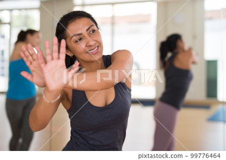 Portrait of young smiling hispanic woman dancing 99776464