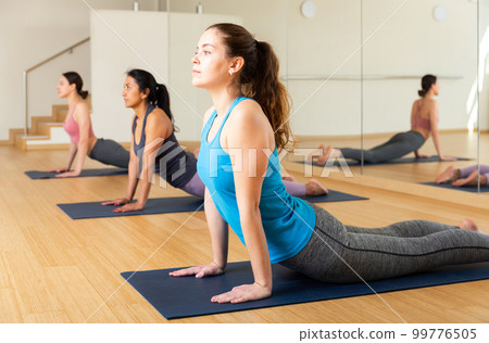 Sporty girl doing stretching asana Urdhva Mukha Shvanasana Sporty girl doing stretching asana Urdhva Mukha Shvanasana 99776505