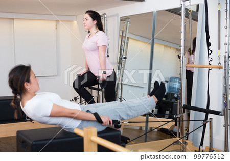 Attractive girls in sportswear training during exercise class in club 99776512