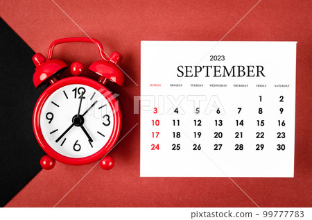 The September 2023 Monthly calendar year with alarm clock on red and black background. The September 2023 Monthly calendar year with alarm clock on red and black background. 99777783