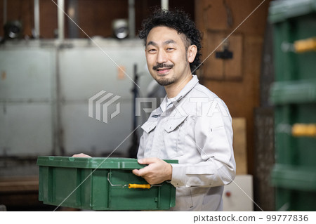 Image of a worker carrying luggage Image of a worker carrying luggage 99777836