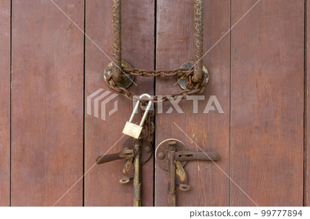 The Closed padlock hangs on the old doors. The Closed padlock hangs on the old doors. 99777894