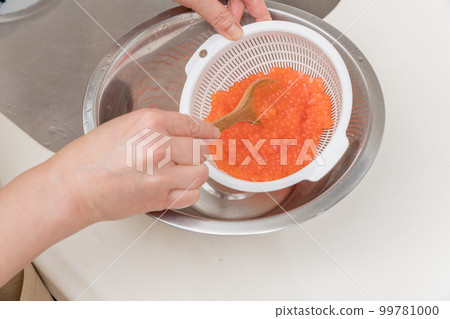 [製作醬油醃製三文魚子，用勺子將洗淨的生三文魚子與清酒混合] 99781000