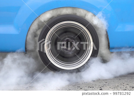 Drag racing car burning tire at starting line in race track Drag racing car burning tire at starting line in race track 99781292