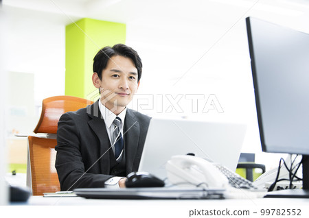 看照相機微笑的辦公室商人膝上型計算機 看照相機微笑的辦公室商人膝上型計算機 99782552