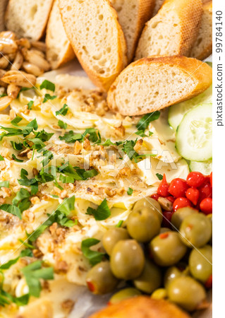 A large vegetarian party butter board with fresh and pickled vegetables and sliced french baguette for a party. A large vegetarian party butter board with fresh and pickled vegetables and sliced french baguette for a party. 99784140