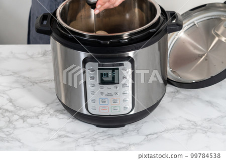 Shredded chicken in a pressure cooker. Cooking chicken breasts in a pressure cooker. 99784538