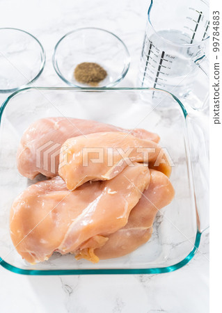 Shredded chicken in a pressure cooker. Measured ingredients in glass mixing bowls to shredded chicken. Shredded chicken in a pressure cooker. Measured ingredients in glass mixing bowls to shredded chicken. 99784883