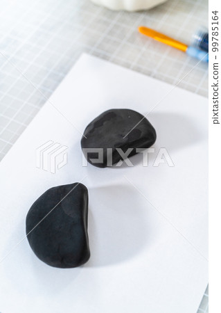 Applying glitter to panda's ears to make panda pumpkin for Halloween. Applying glitter to panda's ears to make panda pumpkin for Halloween. 99785164