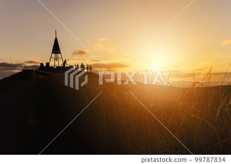 The beautiful sunset and the silhouette of tourist on the summit of Mt.Eden an iconic volcano in Auckland, New Zealand. 99787834