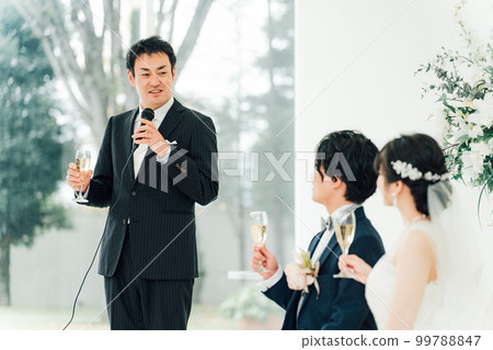 A man and the bride and groom giving a toast at a wedding 99788847