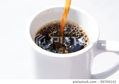 將剛煮好的咖啡倒入杯子中 將剛煮好的咖啡倒入杯子中 99789142