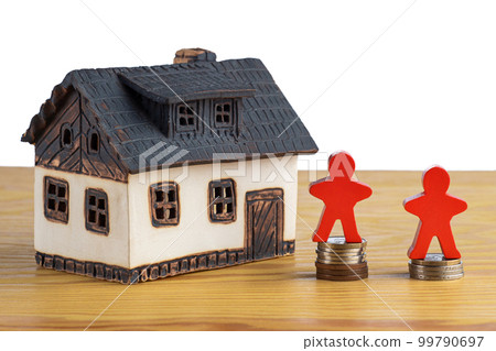 House with stacks of money and a figure model symbolizing rising real estate prices. House with stacks of money and a figure model symbolizing rising real estate prices. 99790697