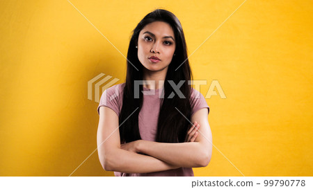 Happy young woman in the studio against a yellow background Happy young woman in the studio against a yellow background 99790778