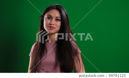 Young confident woman against a green background 99791125