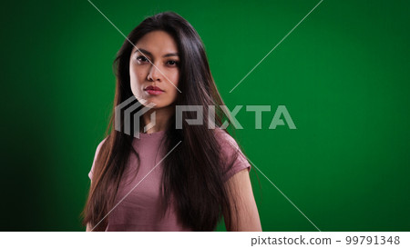 Young confident woman against a green background 99791348