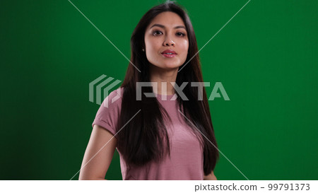 Young pretty woman in the studio posing against a green background 99791373