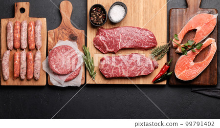 Various raw meat and fish. Steaks, sausages, salmon and spices Various raw meat and fish. Steaks, sausages, salmon and spices 99791402